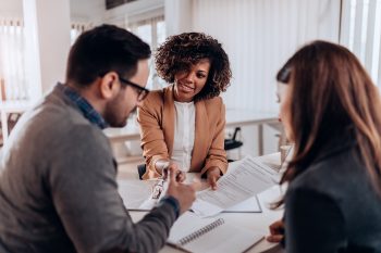 Couple sitting at desk getting assistance with home buying