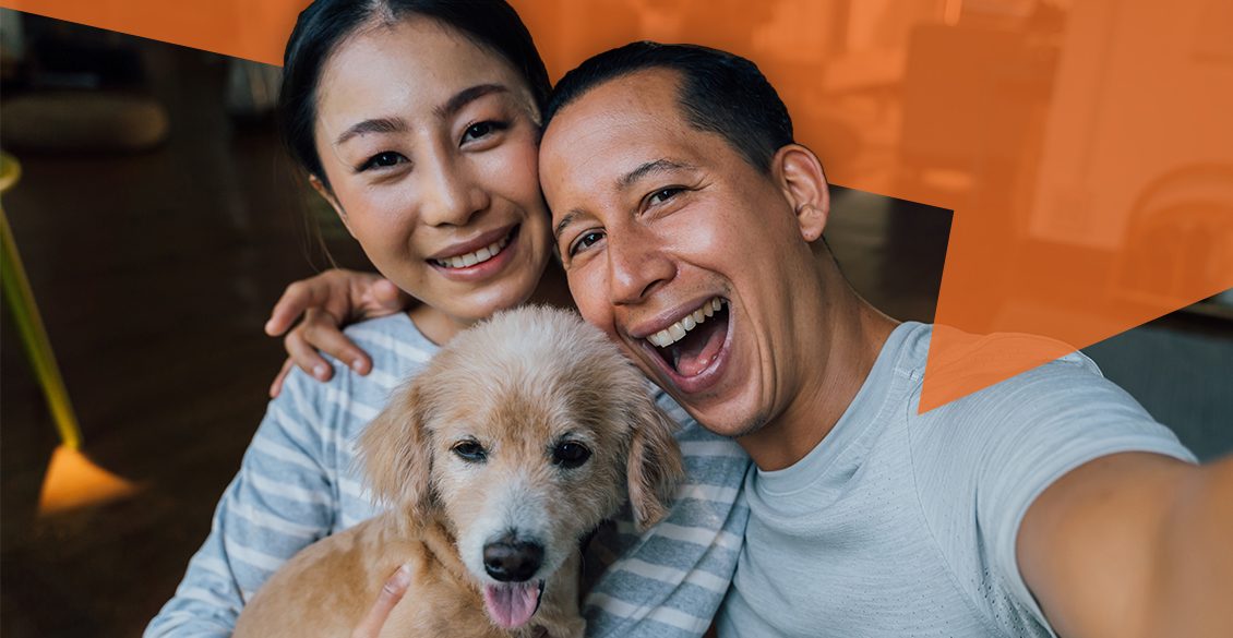 Selfie of a man and woman smiling with a dog