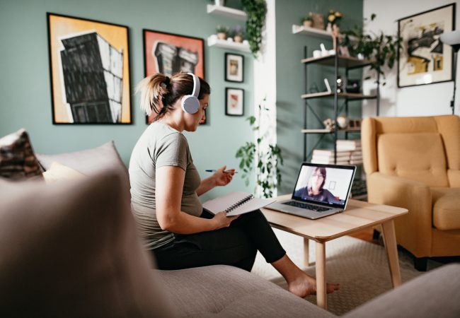 Young white woman at home teleconferencing on computer for meeting