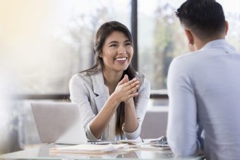 Smiling businesswoman meets with a male colleague.