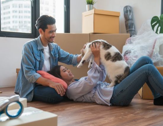 Young Asian couple moving into new home with cat