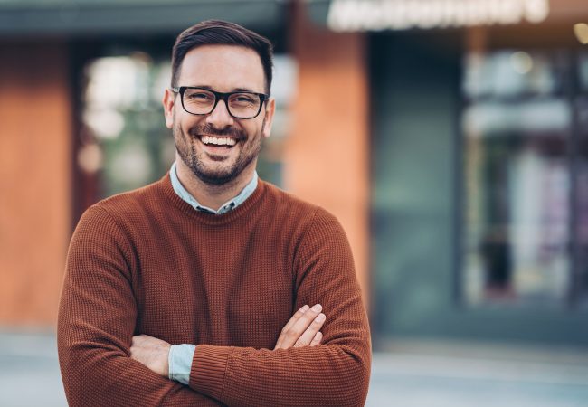 Man smiling with arms crossed