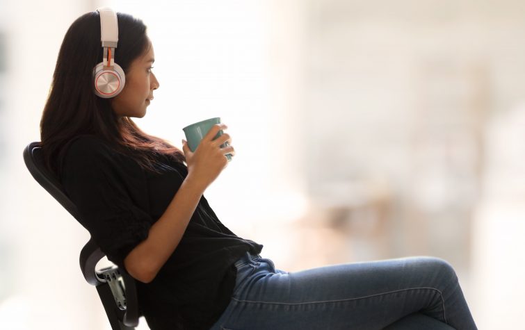 Woman at work wearing headphones looking relaxed