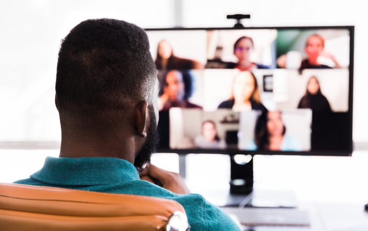 A mid adult businessman meets with his colleagues during a video conference.