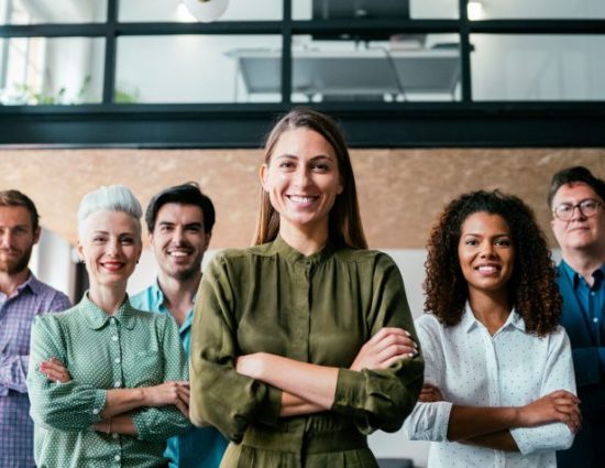 Smiling businesswoman standing with her successful team