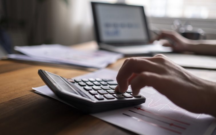 Business man using calculator with laptop