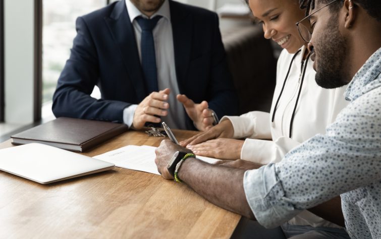 Confirming deal. Close up of happy african husband wife signing up contract in presence of lawyer financial advisor. consultation