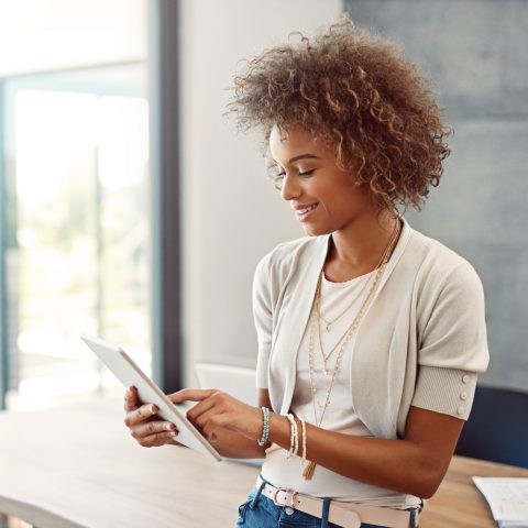 Shot of a young woman working at home with a digital tablet