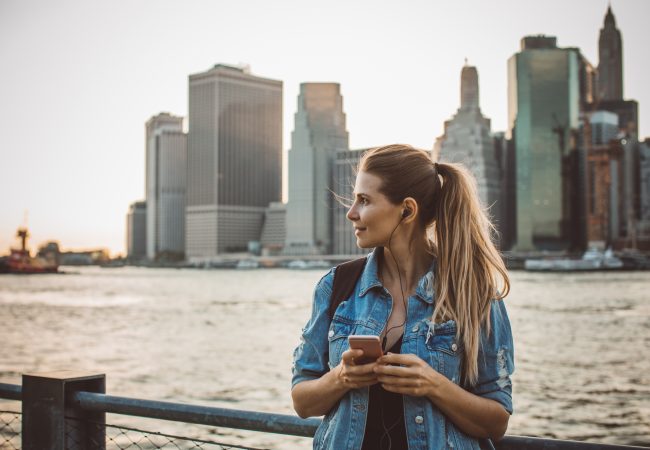 Woman standing on platform with city scape behind her