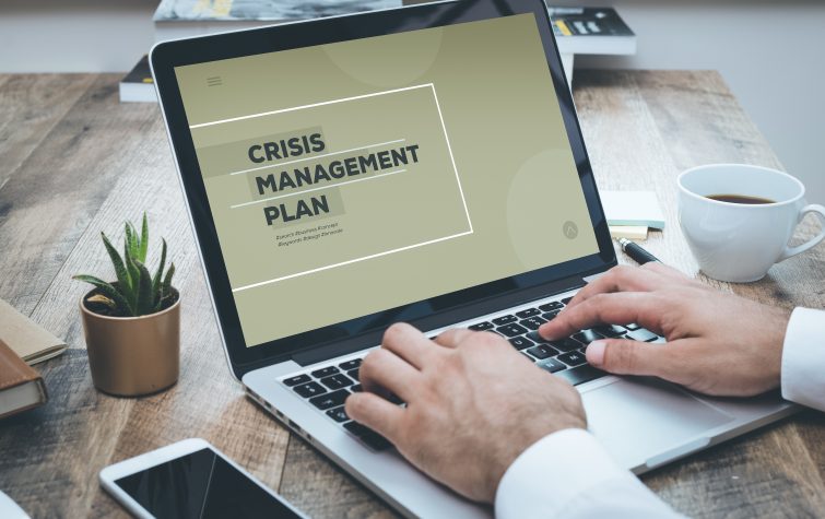 Person working on a crisis management plan on a laptop