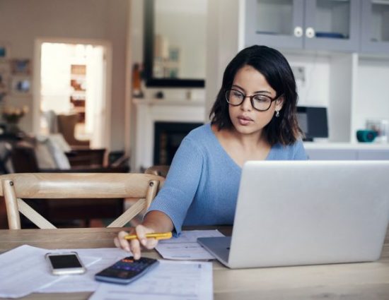 Young woman using a laptop and calculator