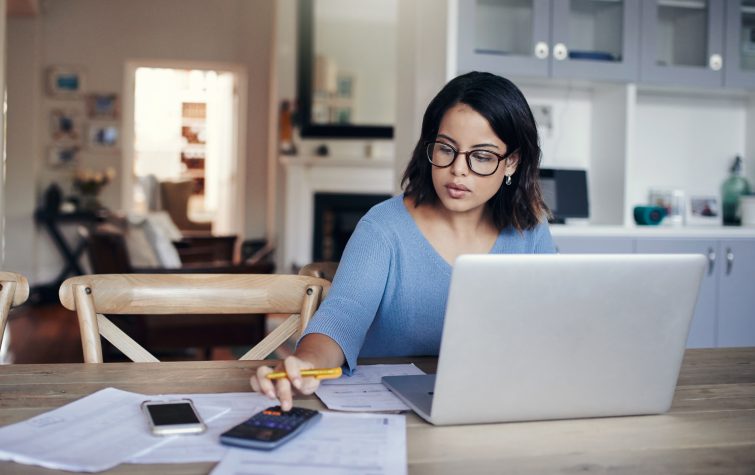 Young woman using a laptop and calculator