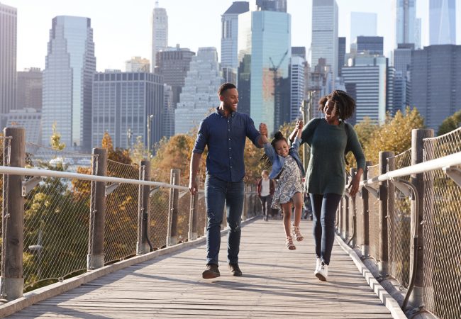 Young family with daughter taking a walk on footbridge