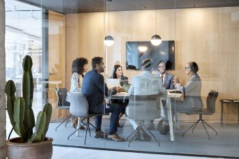 Senior businesswoman explaining strategy with colleagues in board room. 