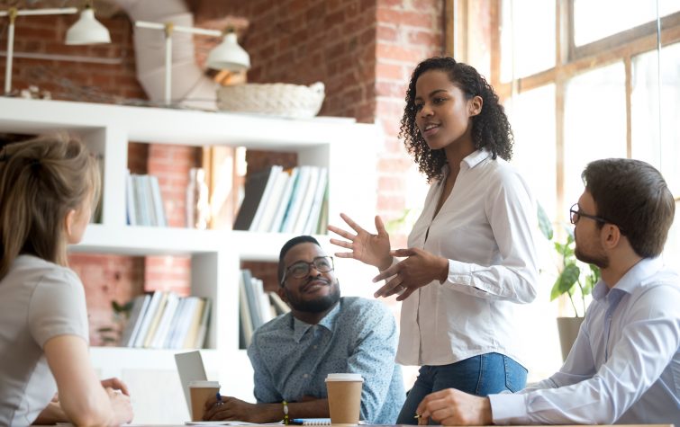 Ambitious female employee speaking at meeting