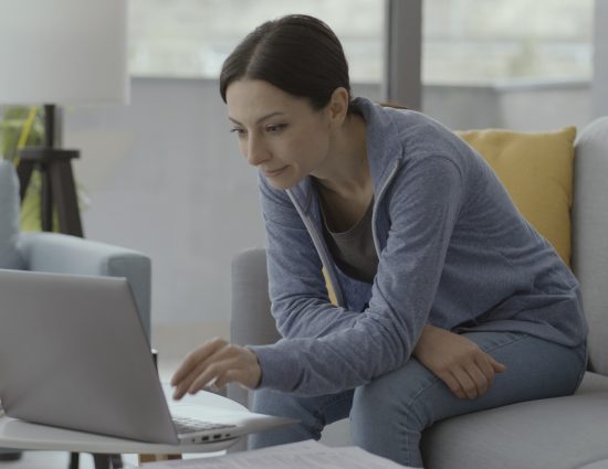 Woman sitting on the couch and working with her laptop