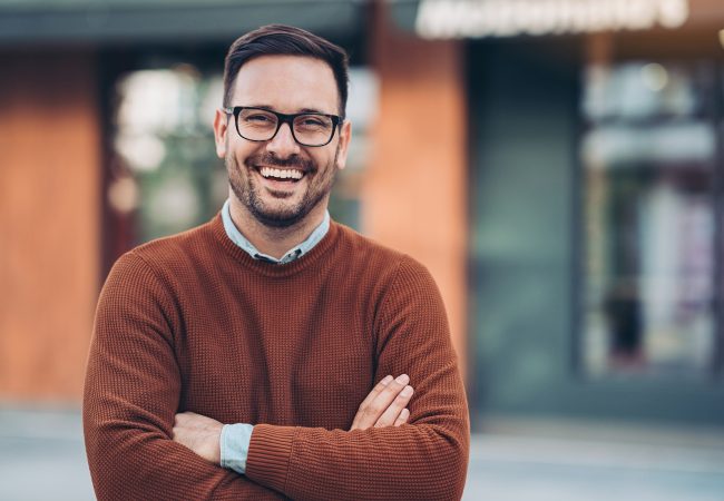 Man smiling with arms crossed