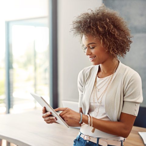 Shot of a young woman working at home with a digital tablet
