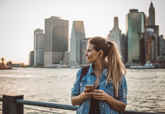 Woman standing on platform with city scape behind her
