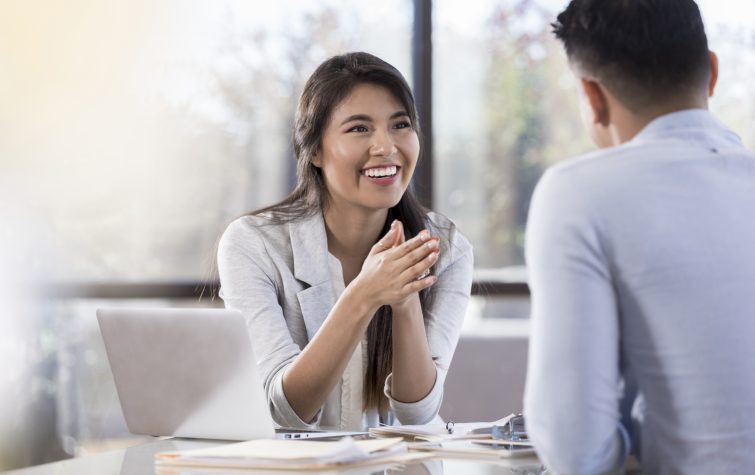 Smiling businesswoman meets with a male colleague.