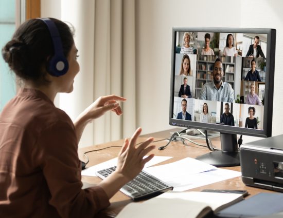 Woman meeting colleagues on video call from home office