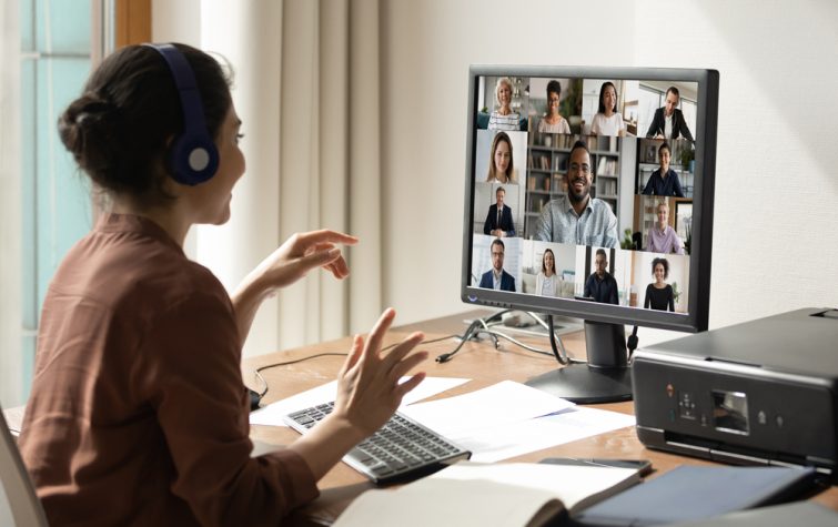 Woman meeting colleagues on video call from home office