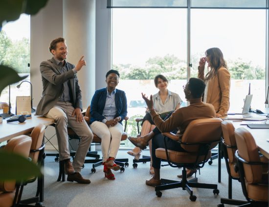 Smiling co-workers talking at their desks