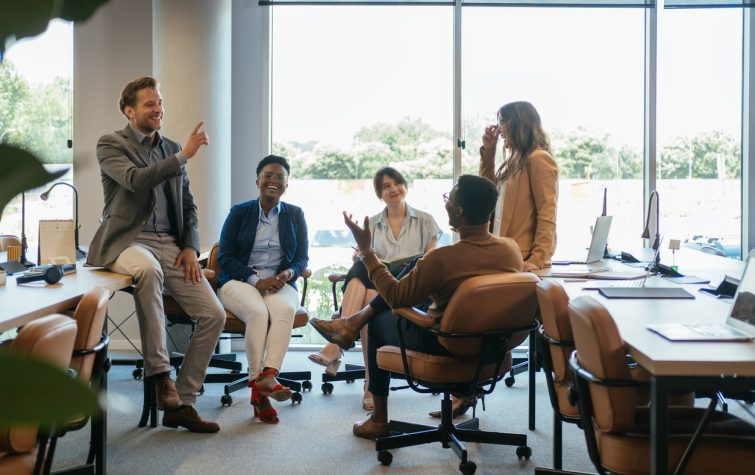 Smiling co-workers talking at their desks