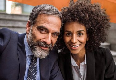 Corporate man and woman sitting on stairs