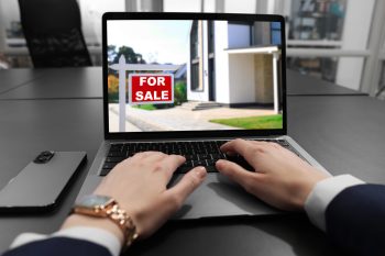 Woman searching for homes on a real estate website during a corporate relocation assignment