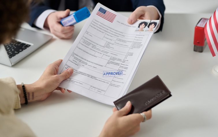 Woman obtaining a U.S. visa at an immigration office representing the growing visa complexity driving outbound global mobility programs
