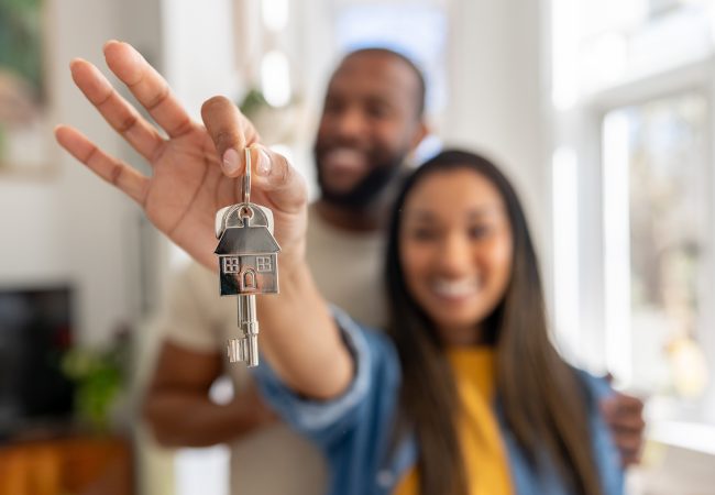 Couple holding the keys to their home during an employee relocation home sale
