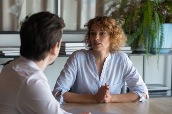 Two colleagues in a supportive meeting representing the pre-decision consulting and policy counseling that improves the employee relocation experience