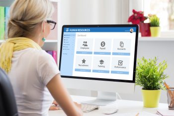 HR professional reviewing compliance and home sale program data on a computer in response to new federal housing legislation