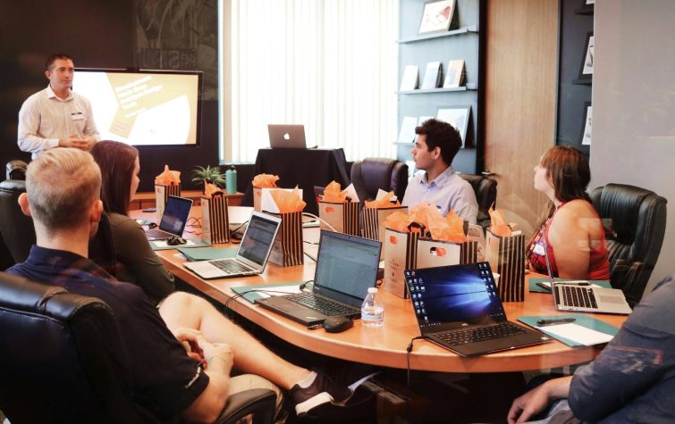 HR team in a conference room reviewing a flexible relocation benefits program presentation with laptops and materials on the table