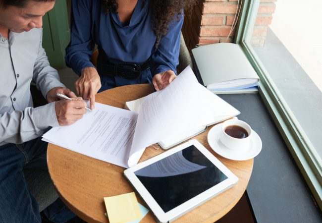 Homeowners reviewing paperwork with an agent while preparing to sell their home