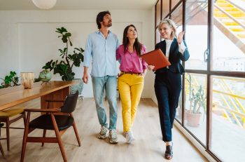 Real estate agent showing a condo apartment to a couple during a corporate relocation home search