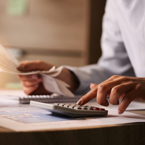 Professional reviewing relocation expenses with a calculator and financial documents