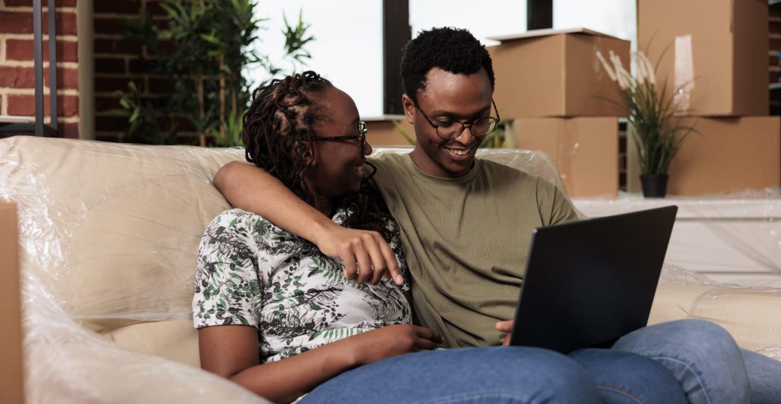Couple using a laptop to search for a new home during an employee relocation