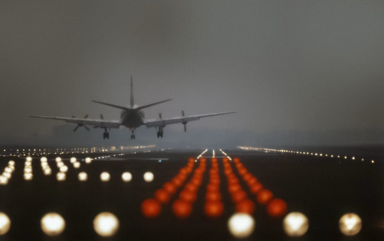 Passenger jet landing on a foggy runway at dusk, representing international assignments and AI-supported global mobility planning