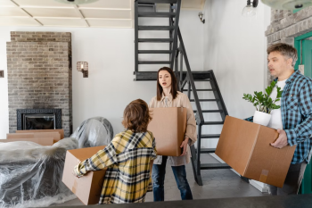 Family with boxes moving into a new home representing the employee relocation experience that global mobility cost decisions directly affect