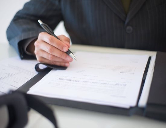 HR professional reviewing relocation policy documents to find global mobility cost savings without cutting talent support