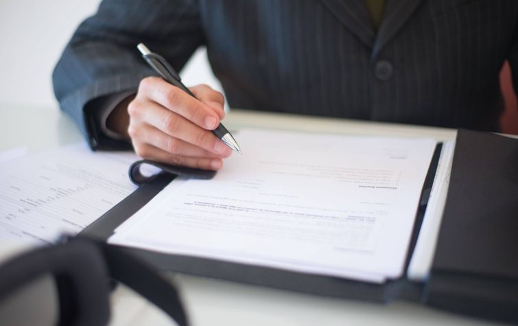 HR professional reviewing relocation policy documents to find global mobility cost savings without cutting talent support