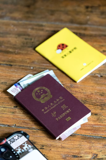 International passport on a wooden surface representing the immigration documentation and work authorization requirements central to global mobility compliance
